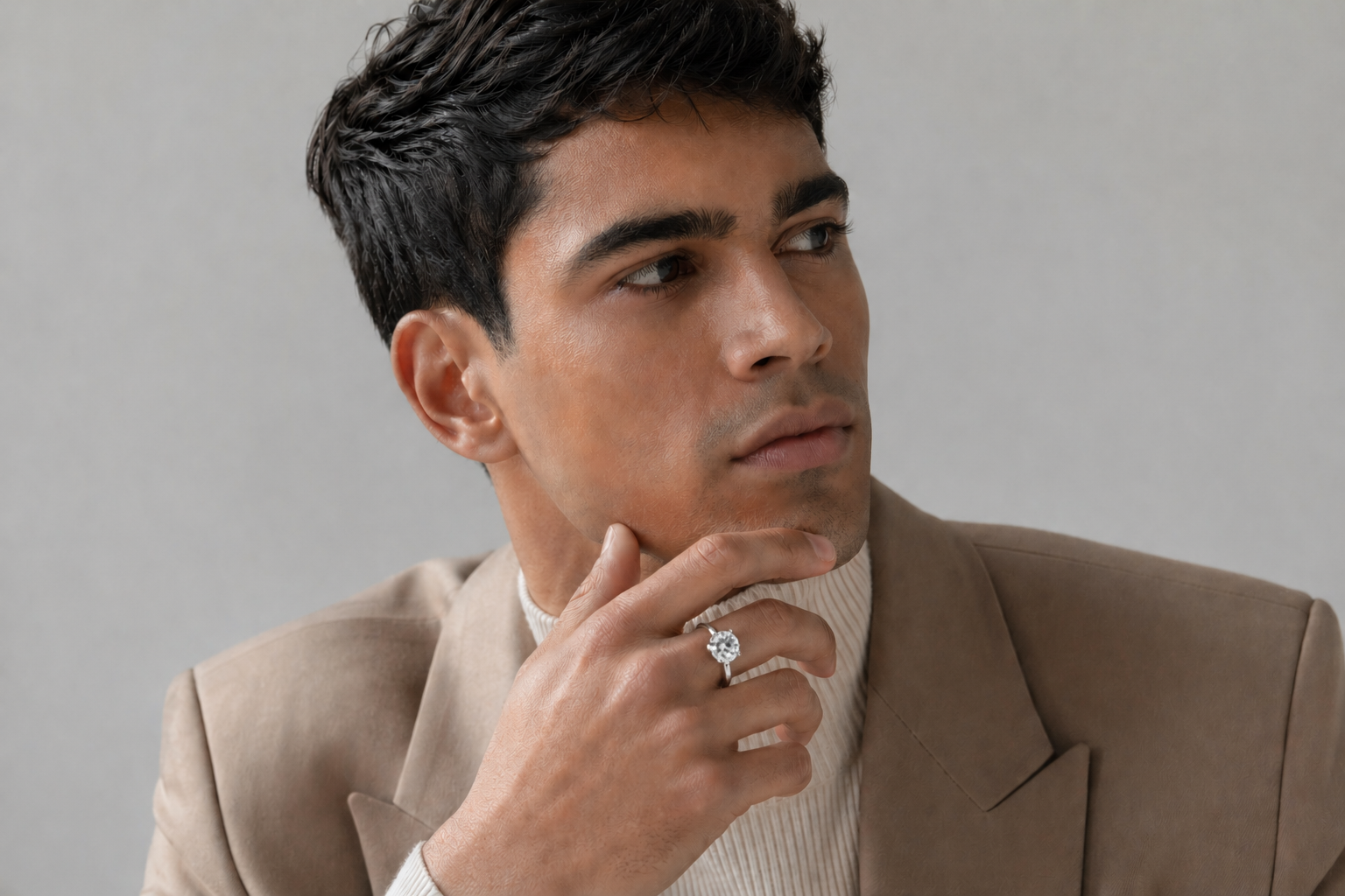 Indian male model with bare torso and denim jacket posing in studio, showcasing a stylish men�s diamond ring on middle finger